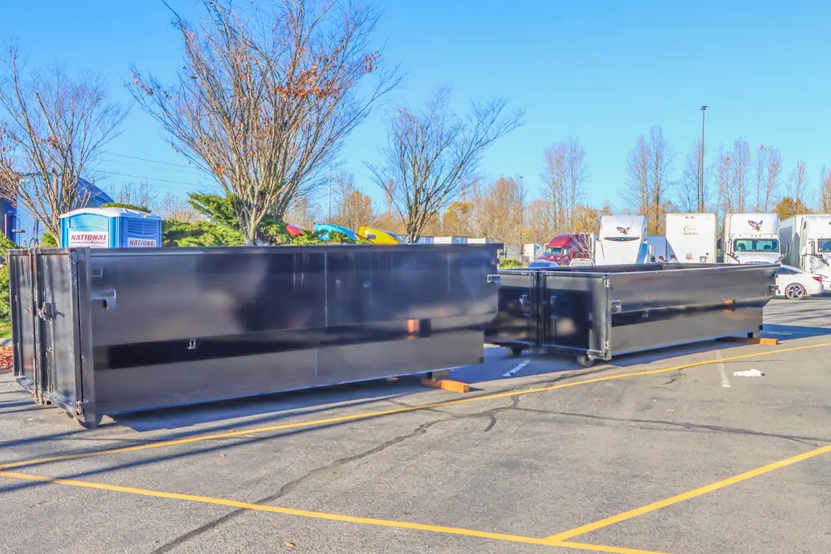 Professional dumpster rental service with roll-off container on residential driveway in Pikesville